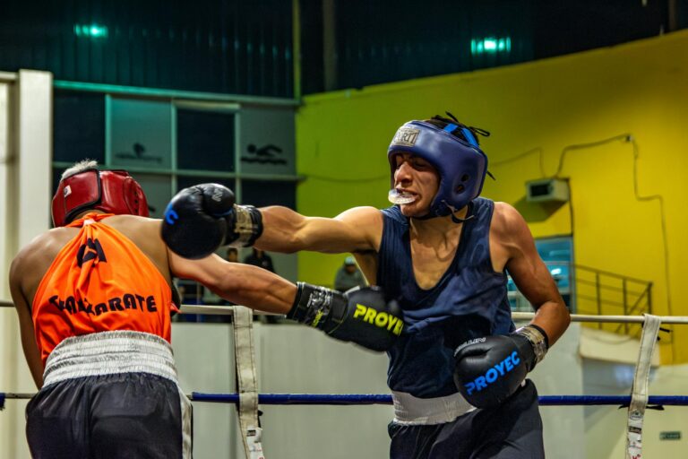 A thrilling boxing fight featuring two men in action wearing protective gear, captured indoors.