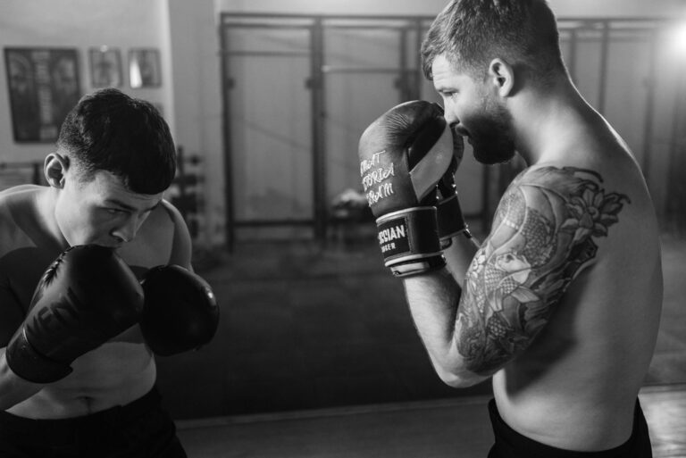 Black and white photo of two boxers sparring in a gym, illustrating strength and focus.