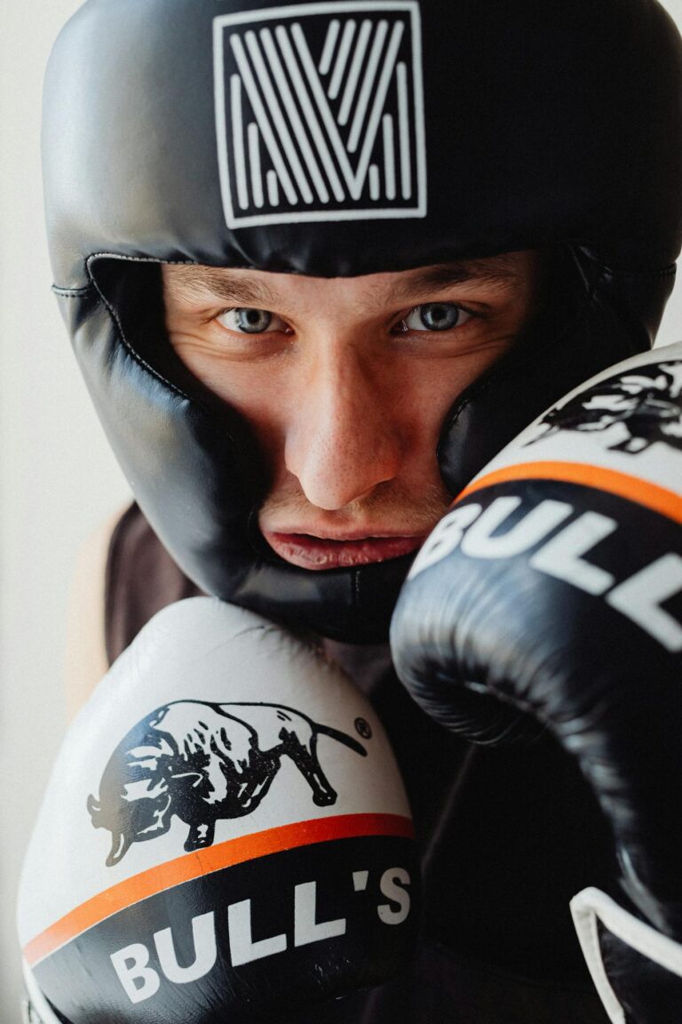 Intense close-up of a male boxer wearing headgear and gloves. Perfect for sports training themes.