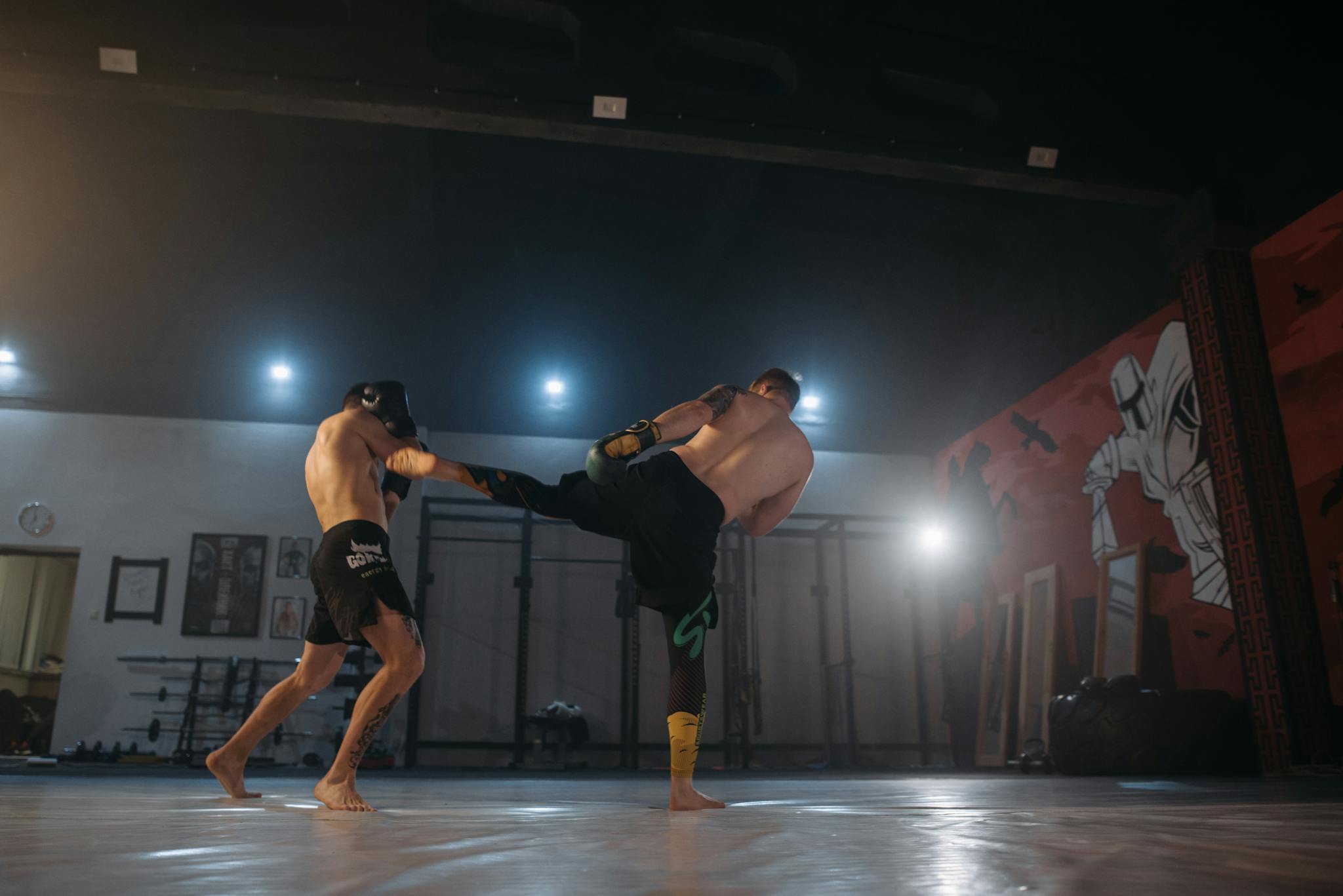 Two male athletes sparring in a martial arts studio, exhibiting strength and agility.